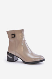 Glossy taupe ankle boot with black block heel and buckle accent on a white background.