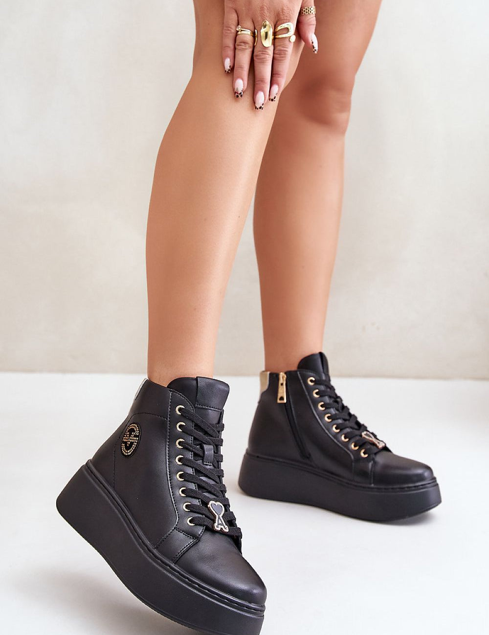 Black Ravella Leather Platform Sneakers with laces and side zipper, worn with a patterned outfit, showcasing sleek and modern style.