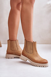 Tan leather ankle boots with platform soles and ribbed elastic sides on a white background.