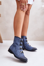 Women's blue ankle boots with buckles and low heel, side view on foot.