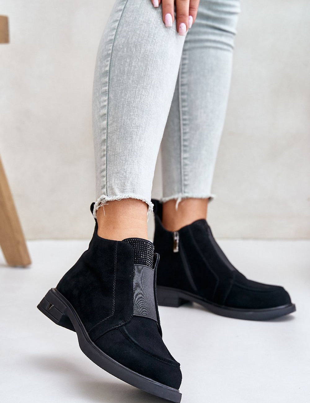 Lunavea suede ankle boots with zip, featuring a flat heel and decorative tongue detail, worn with light denim jeans for a casual look.