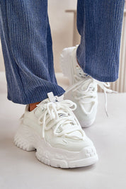 Person wearing white Varetta Chunky Lace-Up Sneakers with thick platform sole and blue pants, showcasing bold silhouette and stylish design.