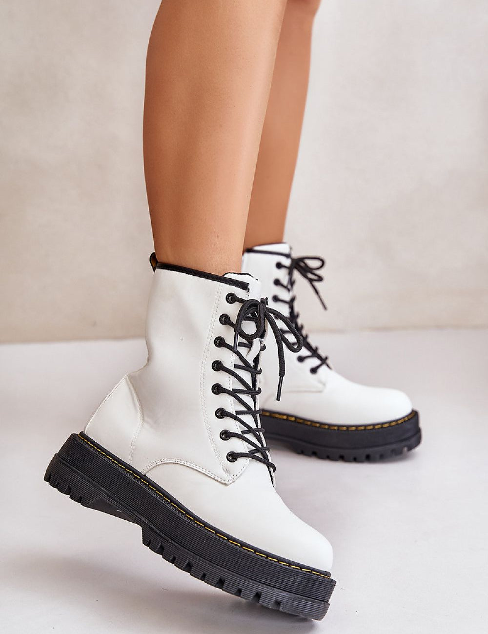 Woman wearing Liravelle Corefit insulated eco leather platform boots with laces and side zipper, elevated on solid platform sole.