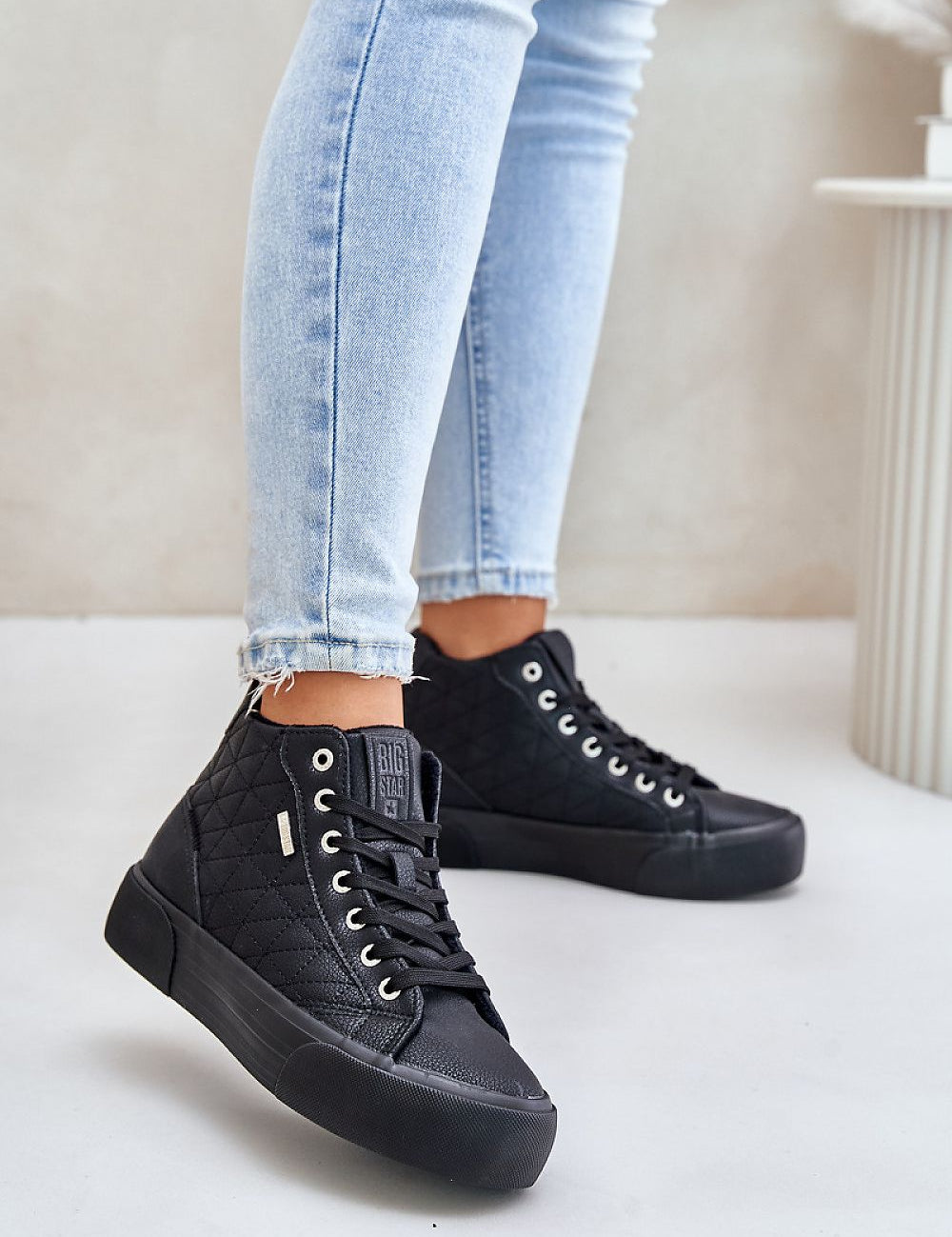 Woman wearing Elbrina Insulated Winter Sneakers in black artificial leather, showing high-top design and platform sole.