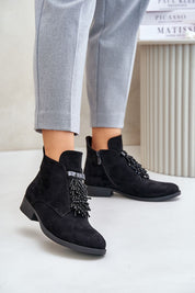 Woman wearing Evarine Frontglow eco-suede ankle boots with embellishment, gray pants, eco-friendly, insulated interior for warmth.