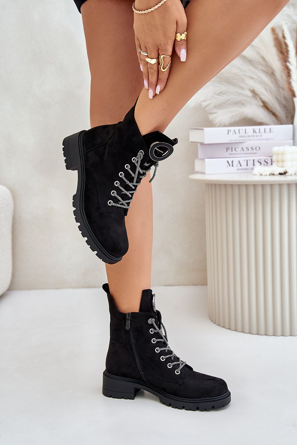 Stylish black eco-suede boots with decorative lacing, side zipper, and flat heel for everyday comfort and cool-weather wear.