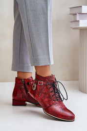 Red Tessara leather lace-up boots with side face detailing and adjustable strap worn with grey pants.