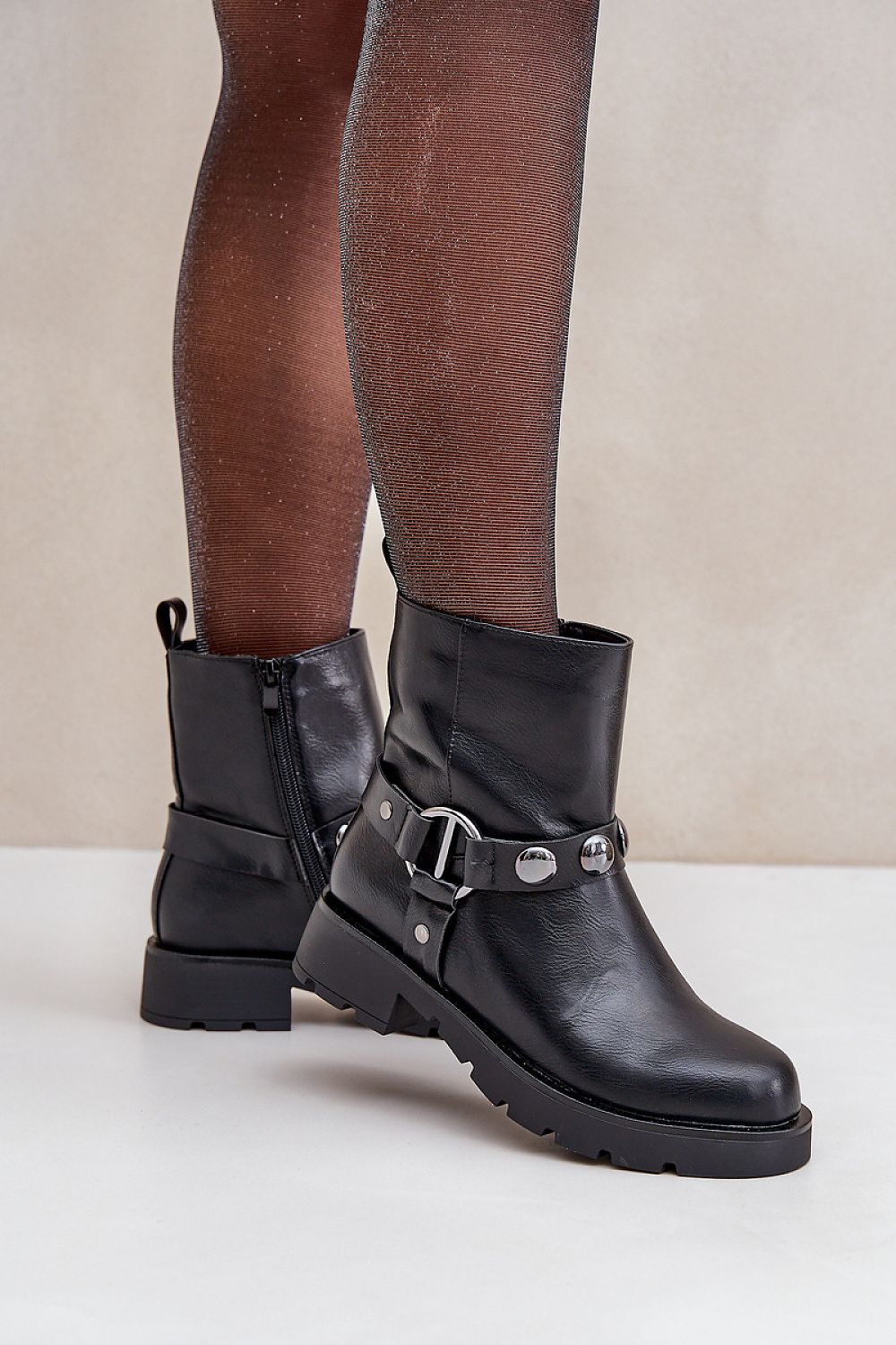 Woman wearing Varita Everyday Ankle Boots with decorative straps and side zipper for casual cold-weather style.