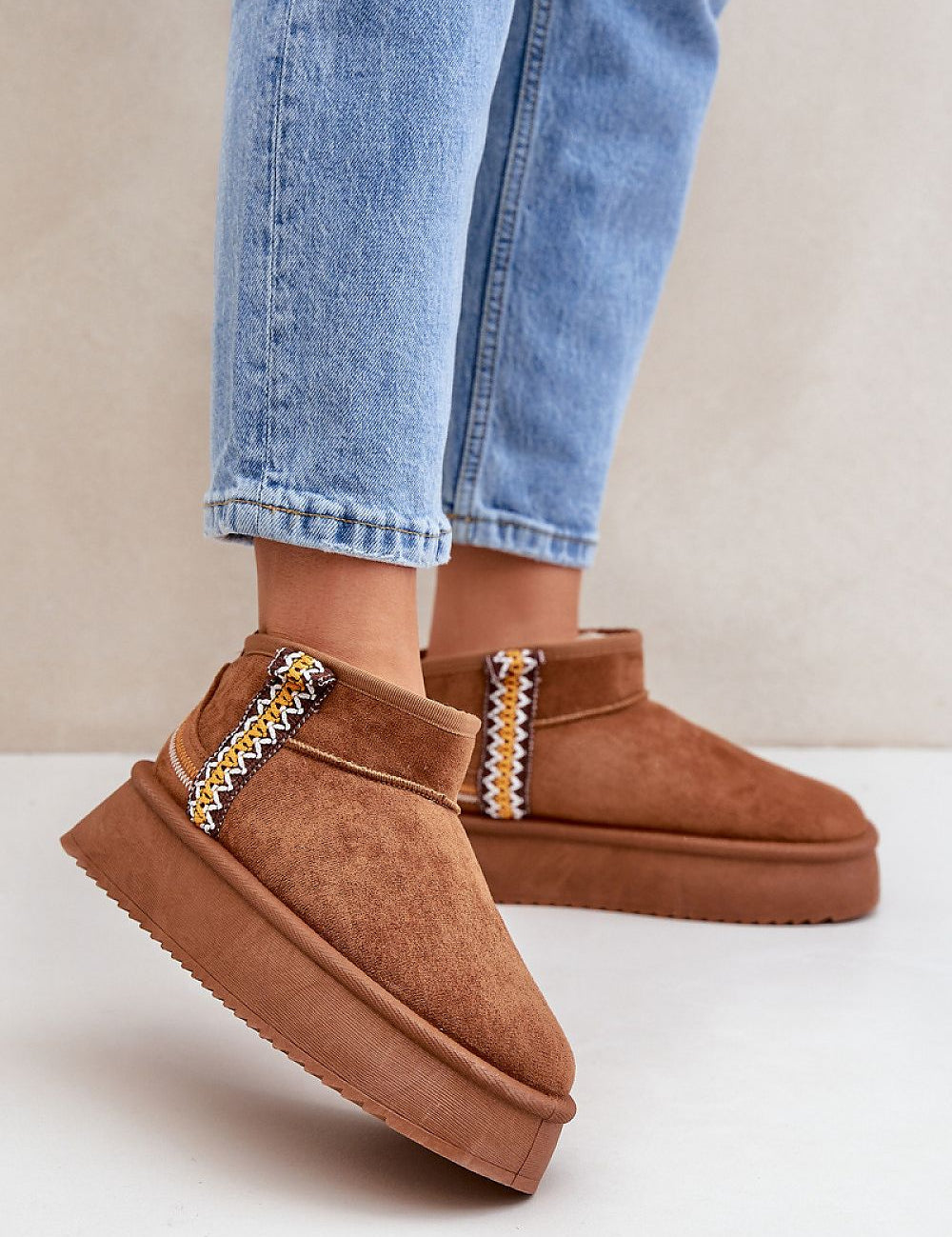 Azmira Aztec platform snow boots with eco suede and plush fur lining, featuring Aztec-inspired pattern, worn with jeans.