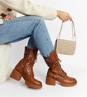 Brown laced ankle boots with heel and side zipper styled with jeans and cream handbag, showcasing chic casual fashion.