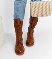 Person wearing Zenvaira Laced Winter Ankle Boots in brown eco leather with jeans, carrying a cream handbag.