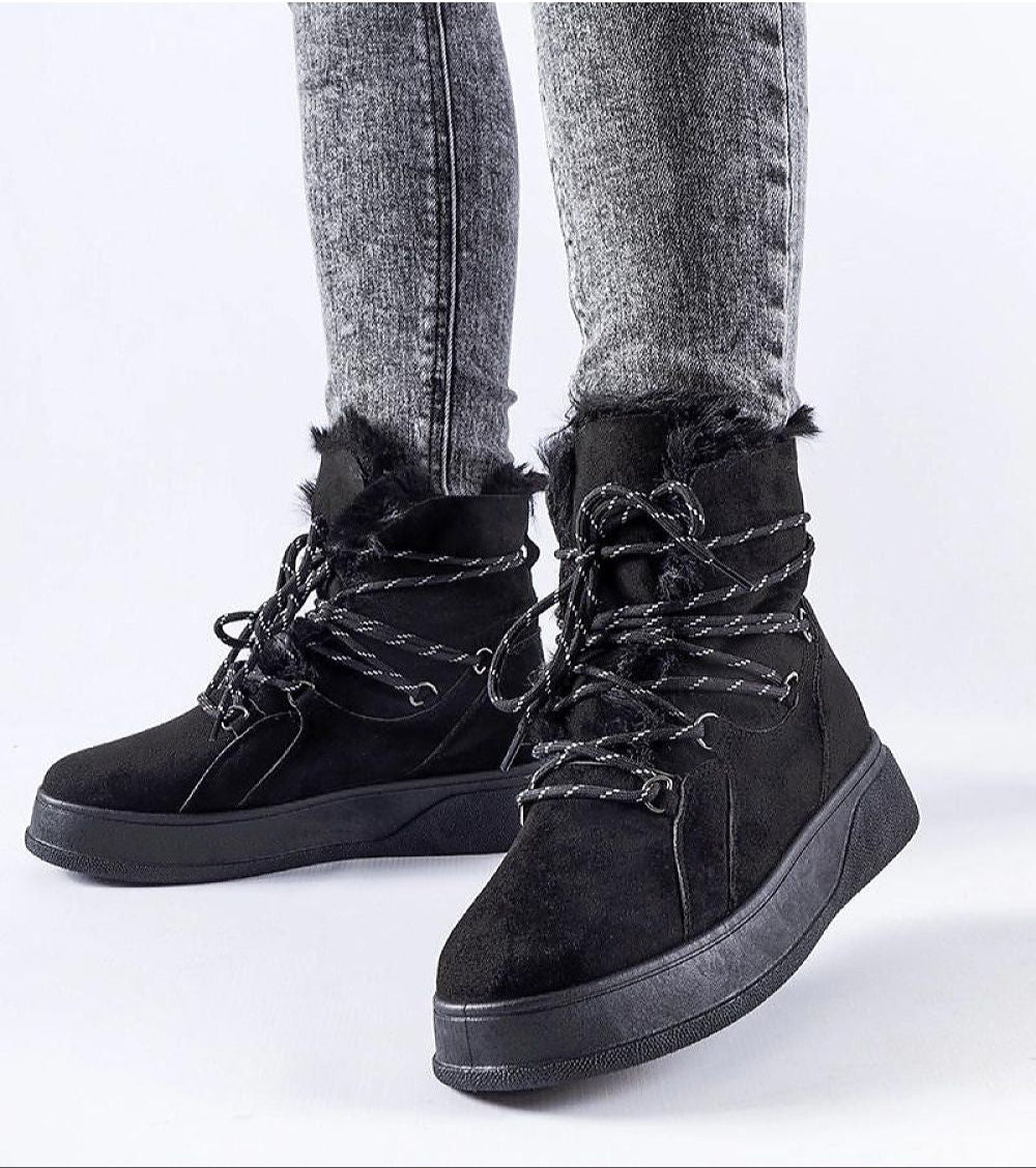 Black Darnelle Platform Winter Snow Boots with fur trim and thick sole, worn by model with grey jeans, ideal for winter weather.