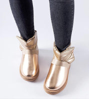 Woman wearing Brivona Glossy Velcro Snow Boots in gold, showcasing a stylish winter look with a comfortable platform and Velcro closure.