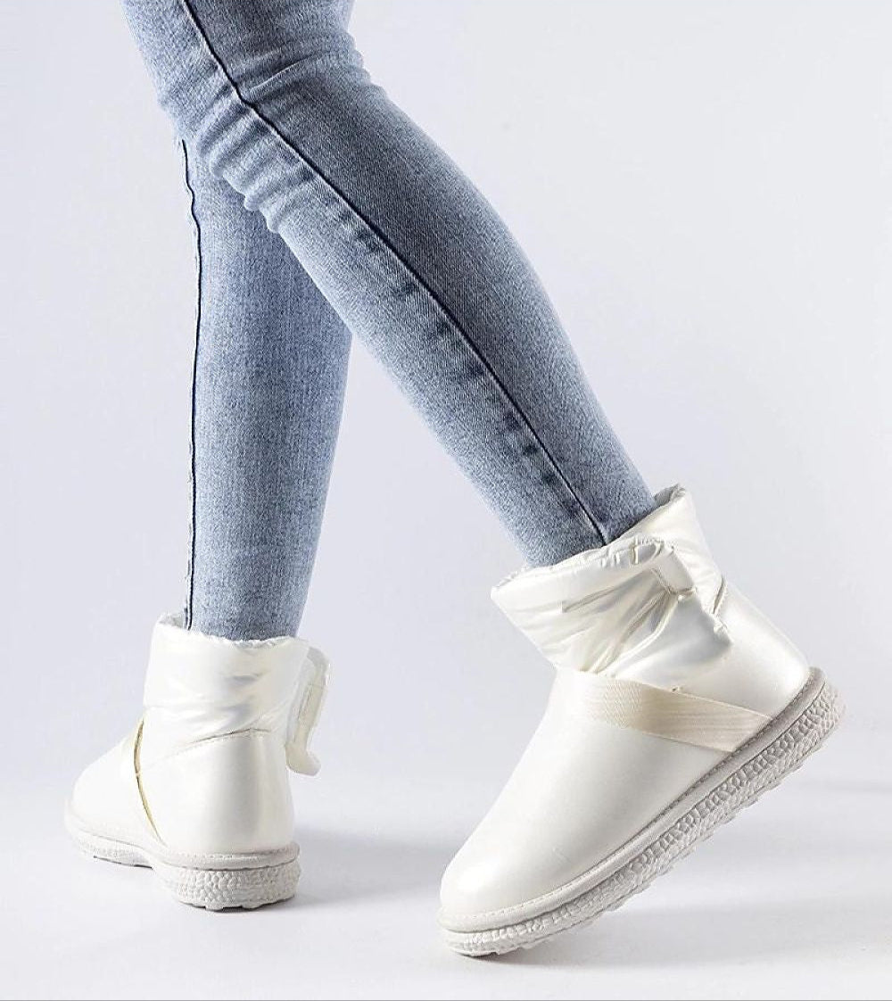 Woman wearing Brivona Glossy Velcro Snow Boots with jeans, showcasing stylish winter footwear with a rounded toe and waterproof design.