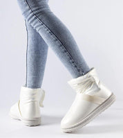 Woman wearing Brivona Glossy Velcro Snow Boots with jeans, showcasing stylish winter footwear with a rounded toe and waterproof design.