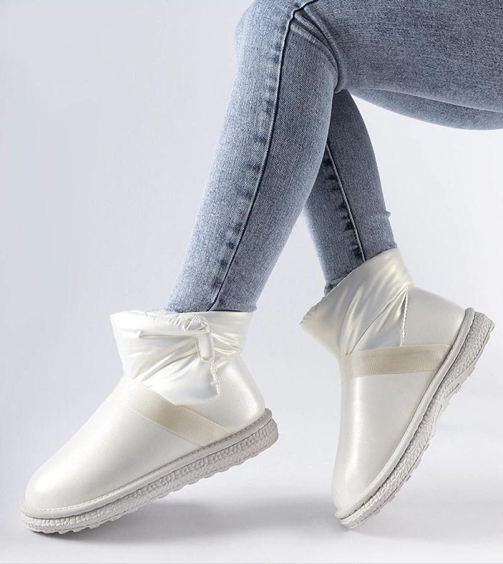 Brivona Glossy Velcro Snow Boots in white with waterproof rubber, worn by a model in jeans, showcasing rounded toe and platform.