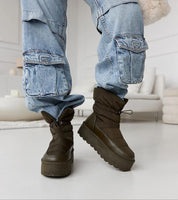 Model wearing Olviera Slip-On Platform Snow Boots in casual setting, showcasing winter practicality and style with a durable rubber sole.