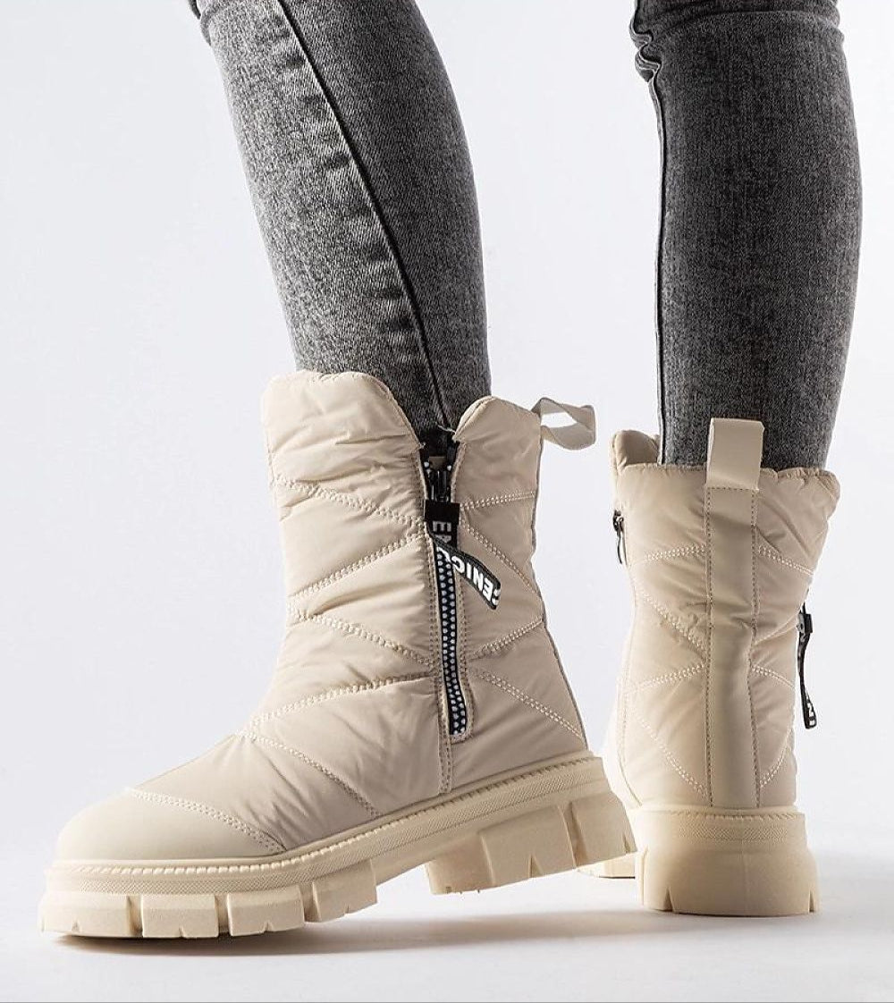 Solvenya Quilted Zip Snow Boots with high shaft and side zipper, shown on person wearing jeans, offering warmth and comfort.