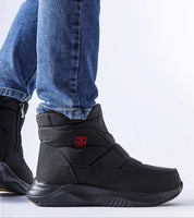 Black Erenelle Short Zip Snow Boots with side zipper, worn with jeans, featuring insulated lining and durable fabric for winter wear.