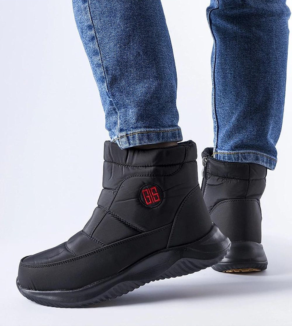 Black short zip snow boots with flat heels worn with jeans, featuring round toe and insulated design for winter comfort and traction.