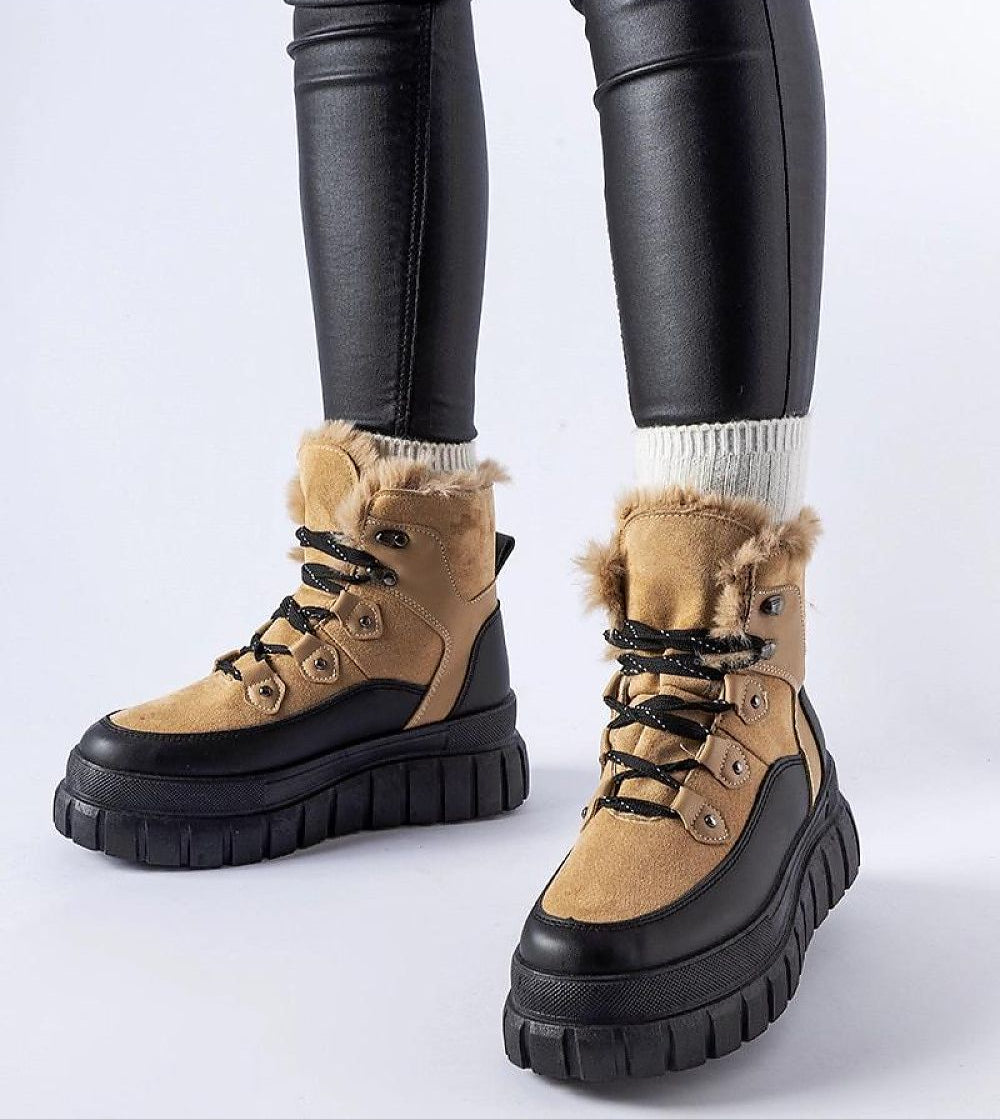 Stylish Norvaya Insulated Ankle Boots with rugged sole and fur lining, ideal for winter wear, shown on person wearing black leggings.
