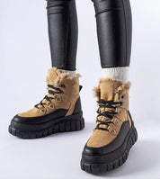 Stylish Norvaya Insulated Ankle Boots with rugged sole and fur lining, ideal for winter wear, shown on person wearing black leggings.