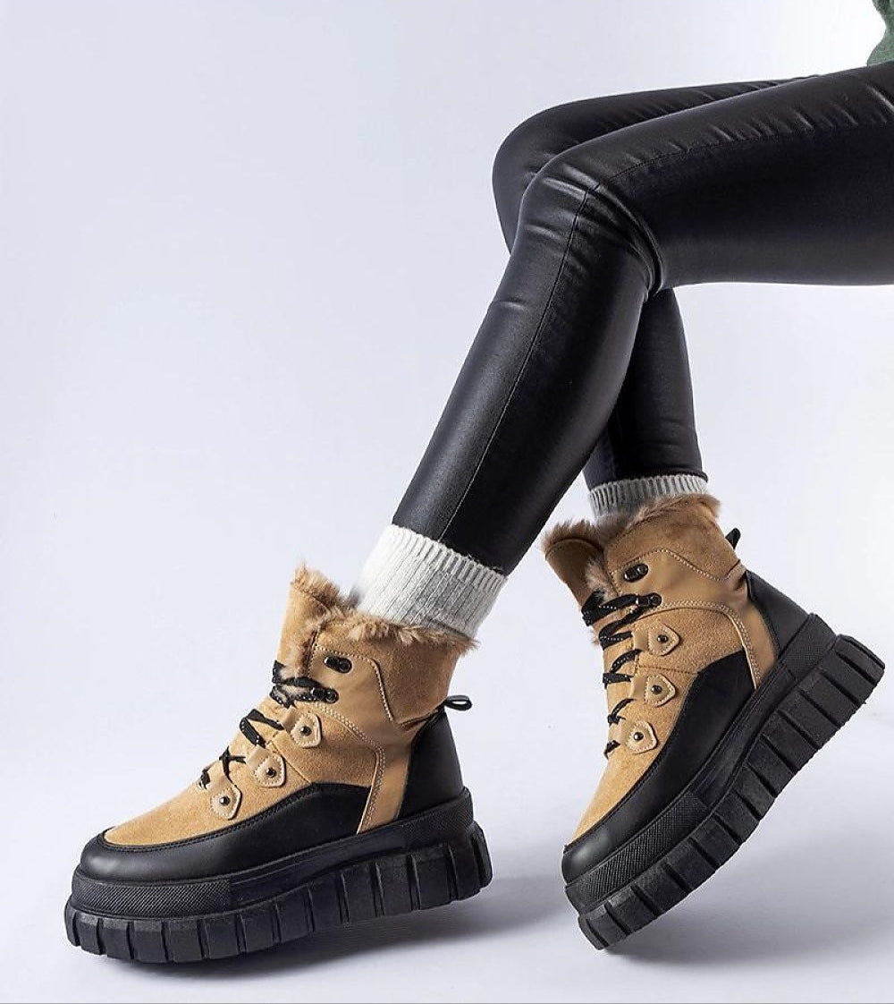 Norvaya Insulated Ankle Boots with rugged sole and lace closure for winter warmth, worn with black leggings.