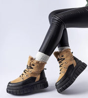 Norvaya Insulated Ankle Boots with rugged sole and lace closure for winter warmth, worn with black leggings.