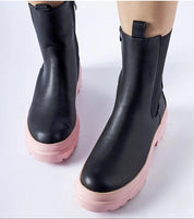 Black ankle boots with pink soles featuring vegan leather upper and side zipper, ideal for winter fashion and comfort.