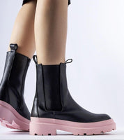 Black ankle boots with pink soles, featuring a sleek design and side zipper, ideal for modern, minimalist fashion and everyday wear.