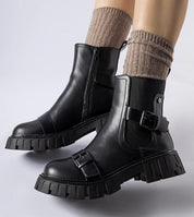 Black insulated heel boots Marvéra with chunky sole and buckles, designed for warmth and style, paired with beige knit socks.