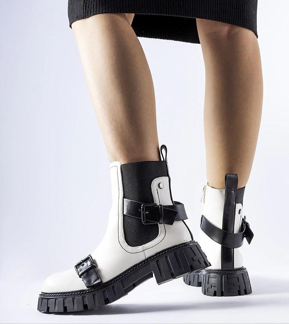 White insulated heel boots with chunky black sole, stylish ankle design, suitable for winter wear. Ideal for fashion and warmth.