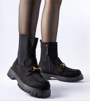 Women's black ankle boots with buckle and side zip, featuring rugged sole and stylish design.