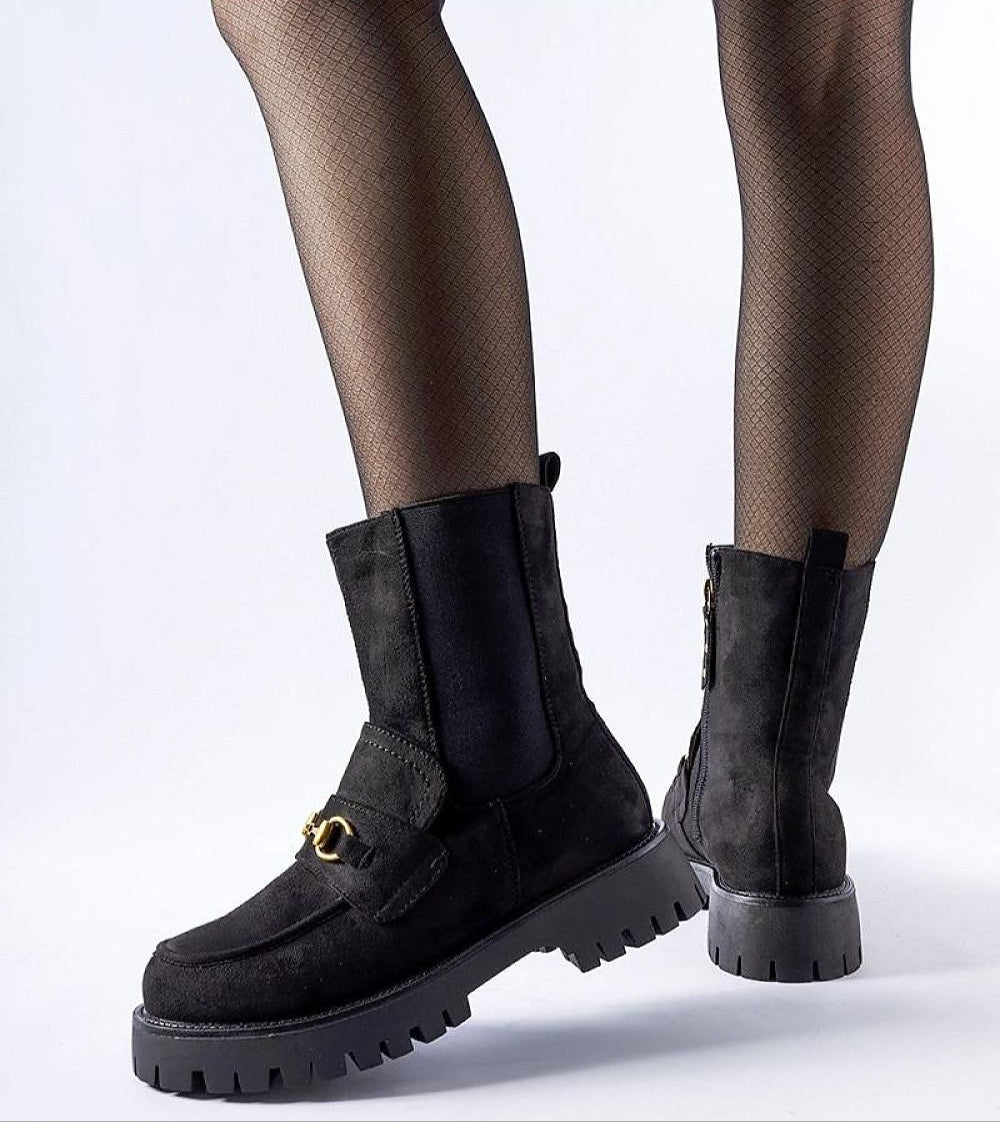 Woman wearing Caelora insulated ankle boots with buckle, featuring eco leather and flat heel for winter comfort and style.