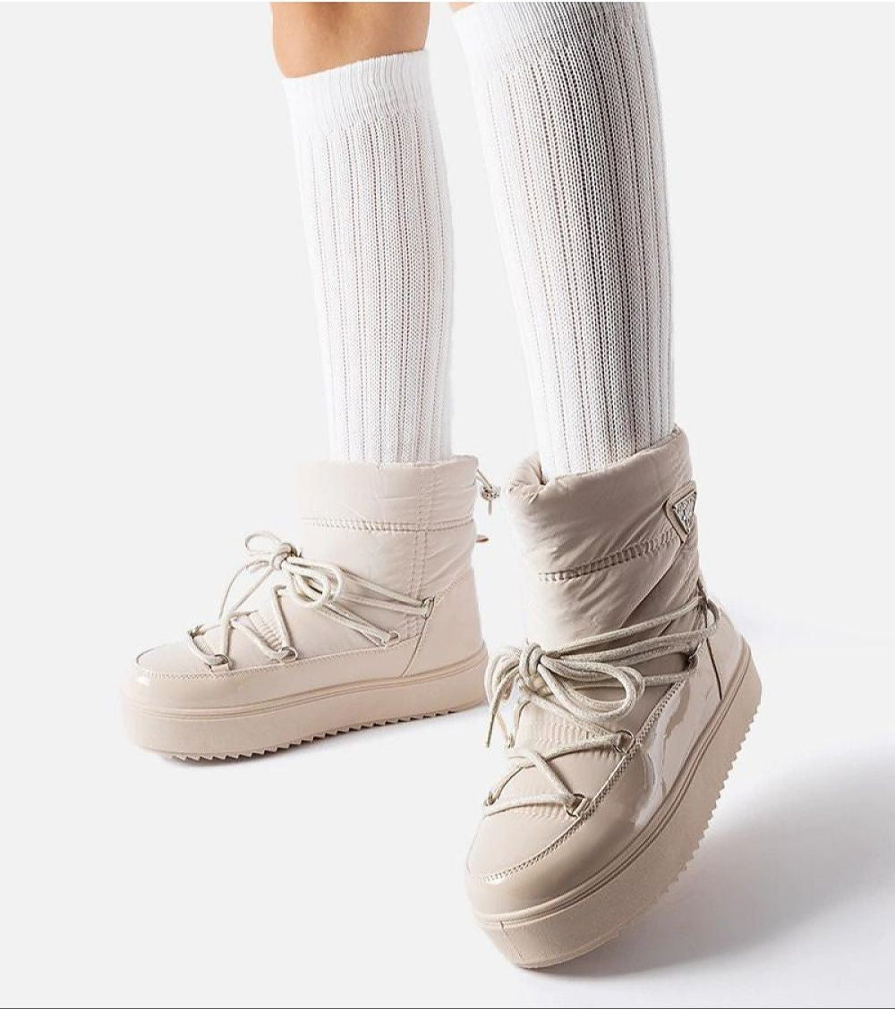 Tharima insulated snow boots in beige with slip-on design, water-resistant rubber, cozy lining, and elevated platform for winter wear.