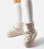 Tharima insulated snow boots in beige with slip-on design, water-resistant rubber, cozy lining, and elevated platform for winter wear.