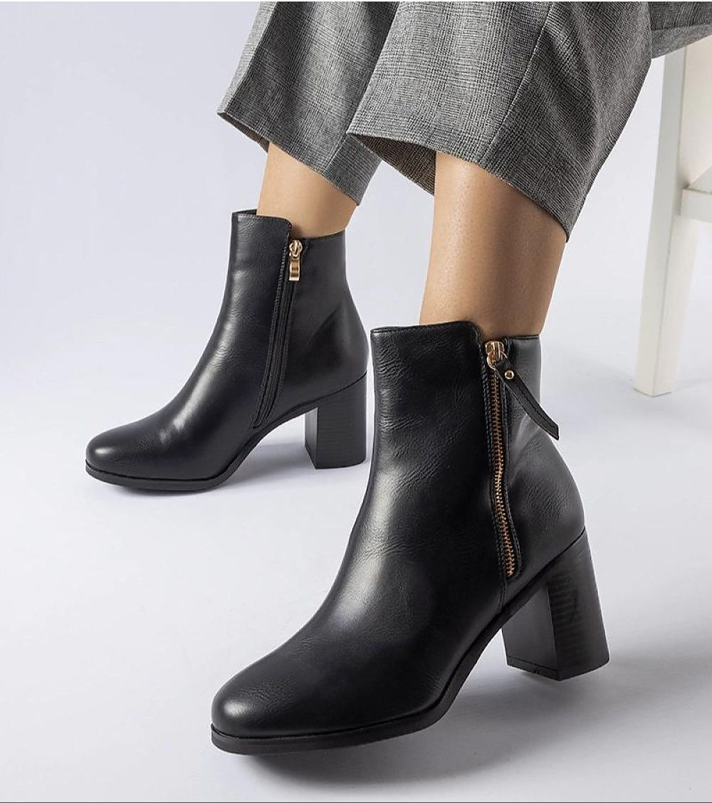 Woman wearing Lyvarra insulated high-heel boots with a side zipper, featuring moisture-resistant eco leather and a sculpted 8 cm heel.