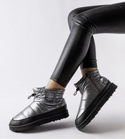 Melvysa insulated snow boots in silver with side zipper, worn with black leggings, featuring eco leather and rubber soles.