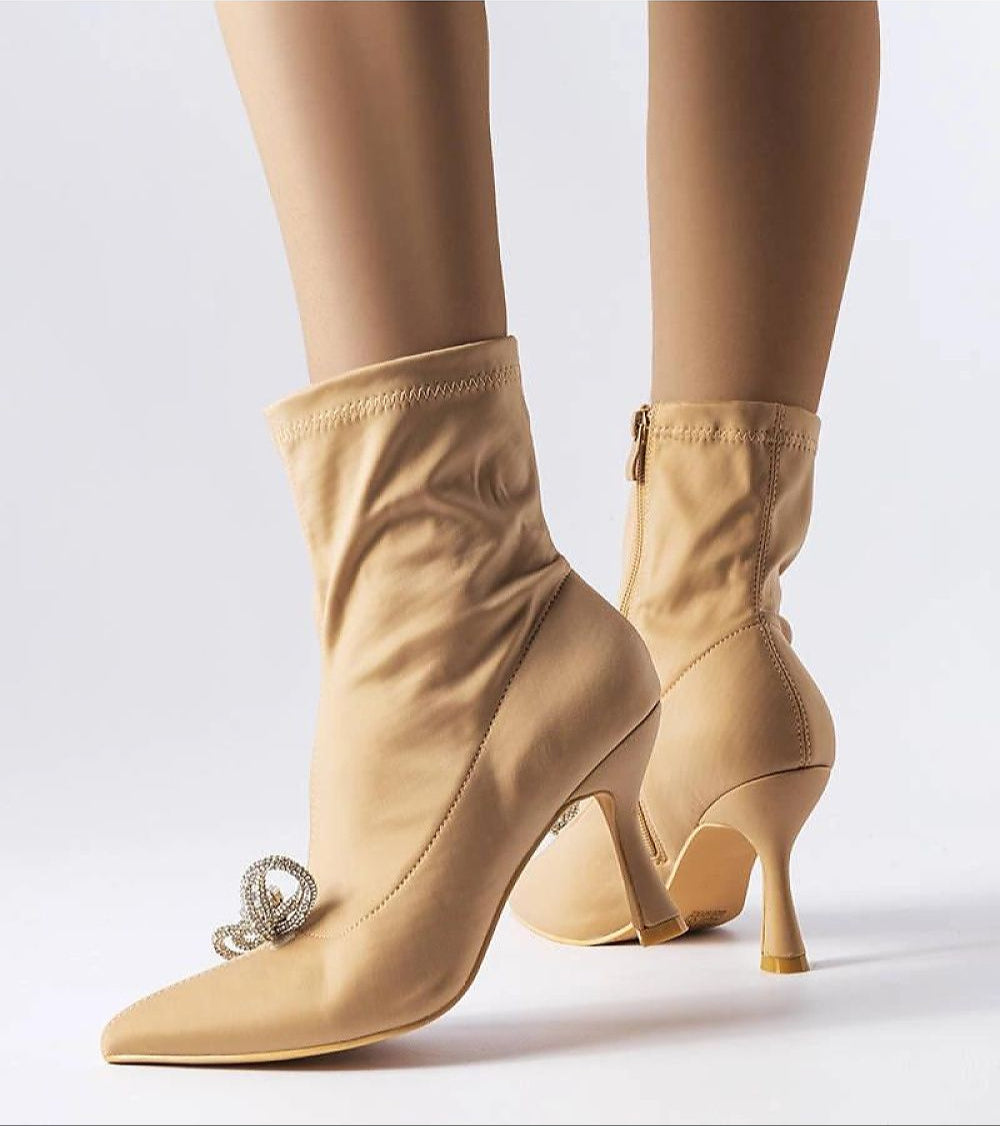 Elegantly crafted Serelune rhinestone bow heel boots in beige, featuring an elongated shaft, sleek 8 cm heel, and sparkling bow detail.