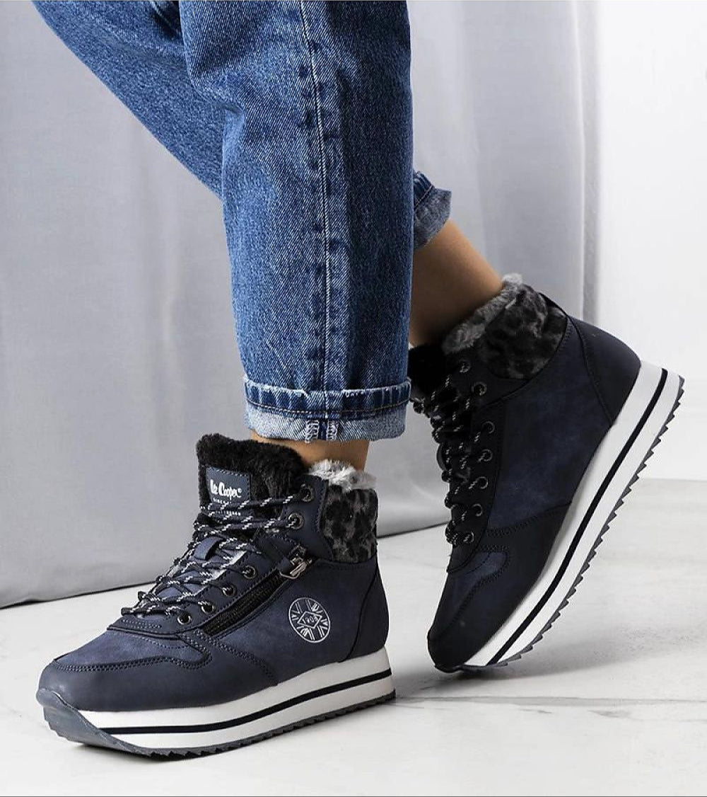 Naverra insulated winter sneakers in navy with fur lining and thick white sole, worn with rolled-up jeans for a cozy, stylish look.