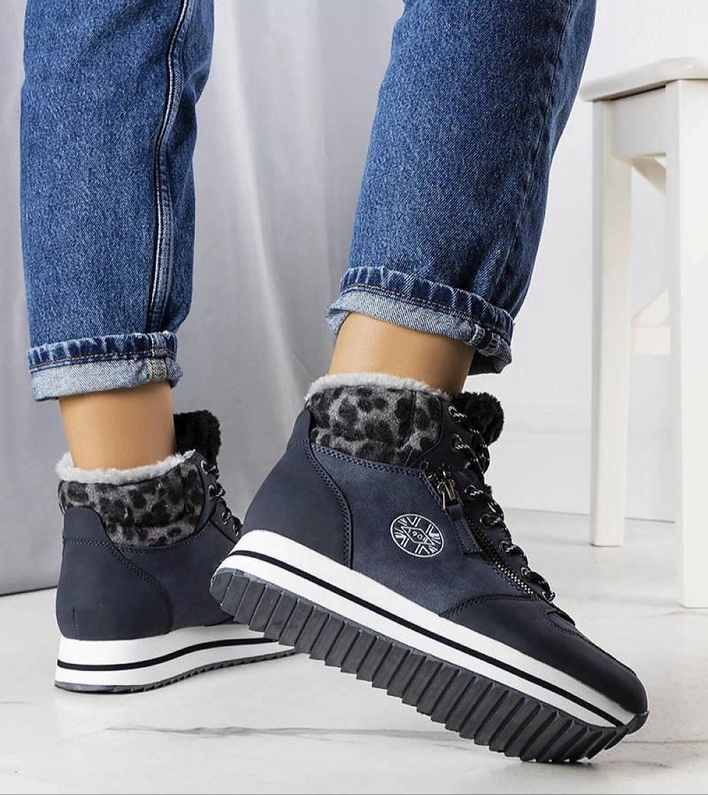 Alt Tag: Naverra insulated winter sneakers with synthetic leather, fur-lined interior, and thick white sole showcased on a person wearing jeans.