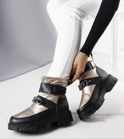 Woman wearing Solvara winter chain snow boots with glossy finish and thick sole, showcasing waterproof panels and eco leather details.