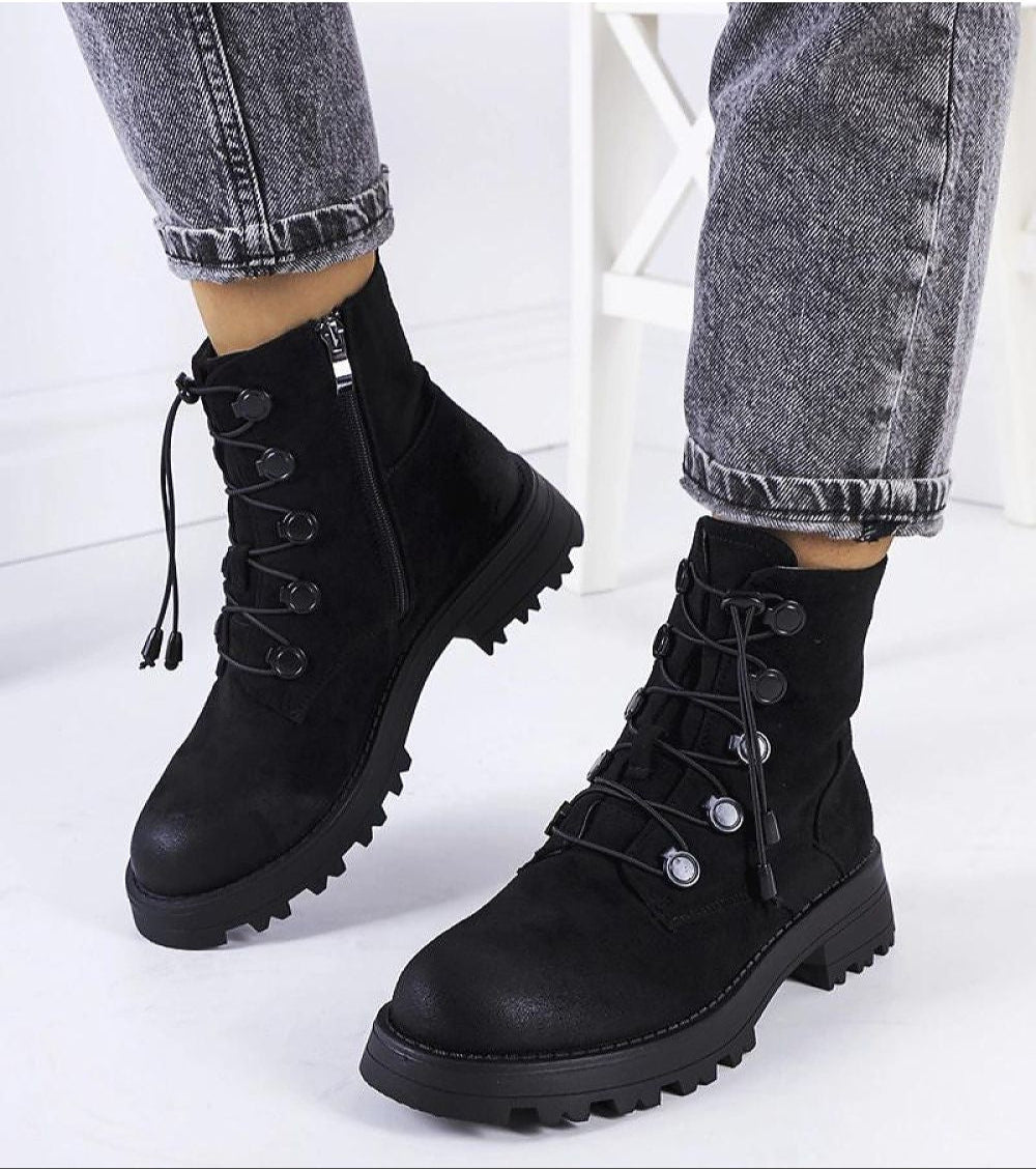 Black eco-suede ankle boots with lace-up front, ridged soles, and side zippers styled with denim jeans.