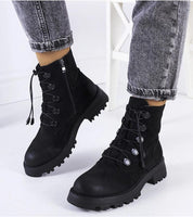 Black eco-suede ankle boots with lace-up front, ridged soles, and side zippers styled with denim jeans.