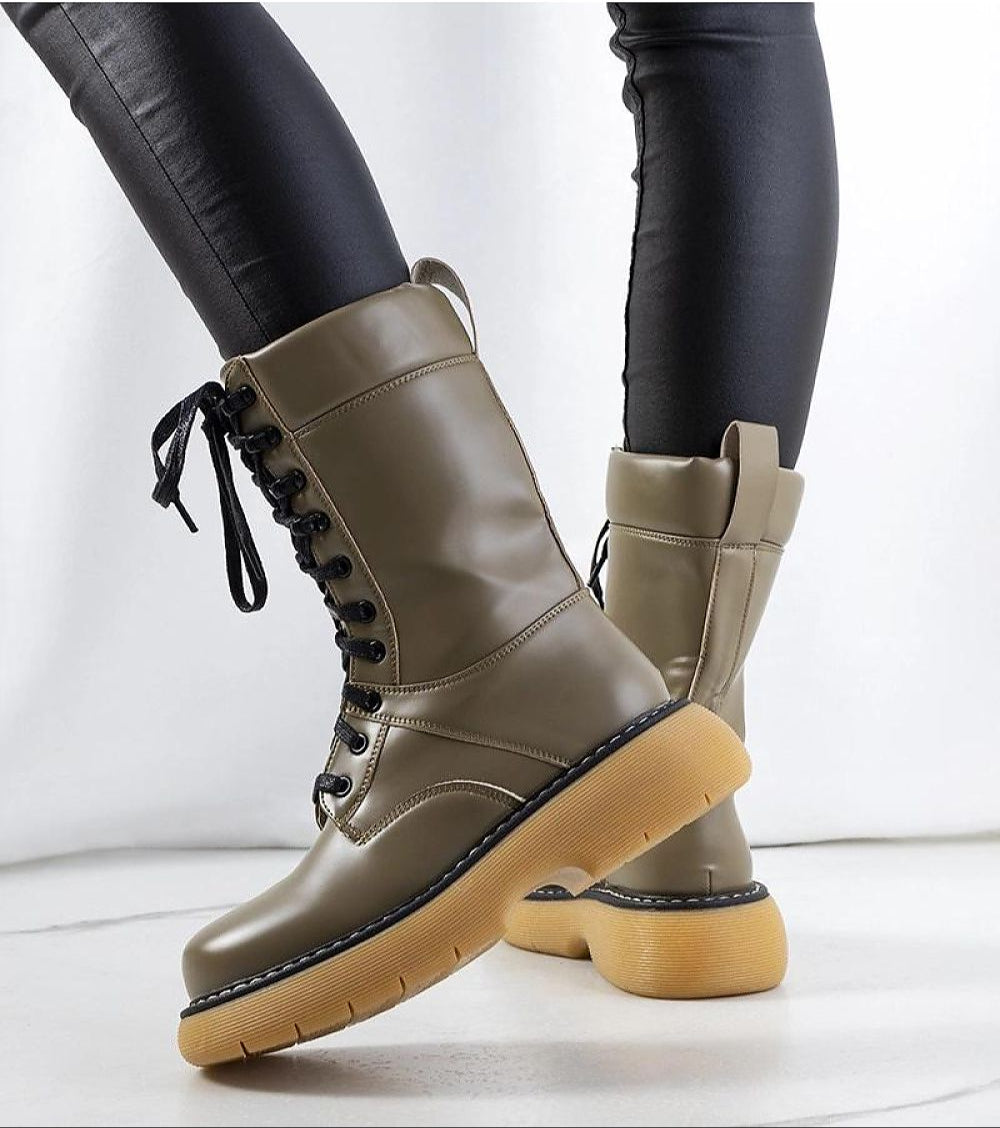 Draxira lace-up combat boots in matte eco leather with thick rubber sole, styled with black leggings for urban streetwear appeal.