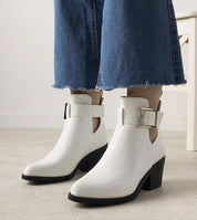 White Alvarine cut-out ankle boots with block heel and ankle strap, crafted in crocodile-effect eco leather, paired with blue jeans.