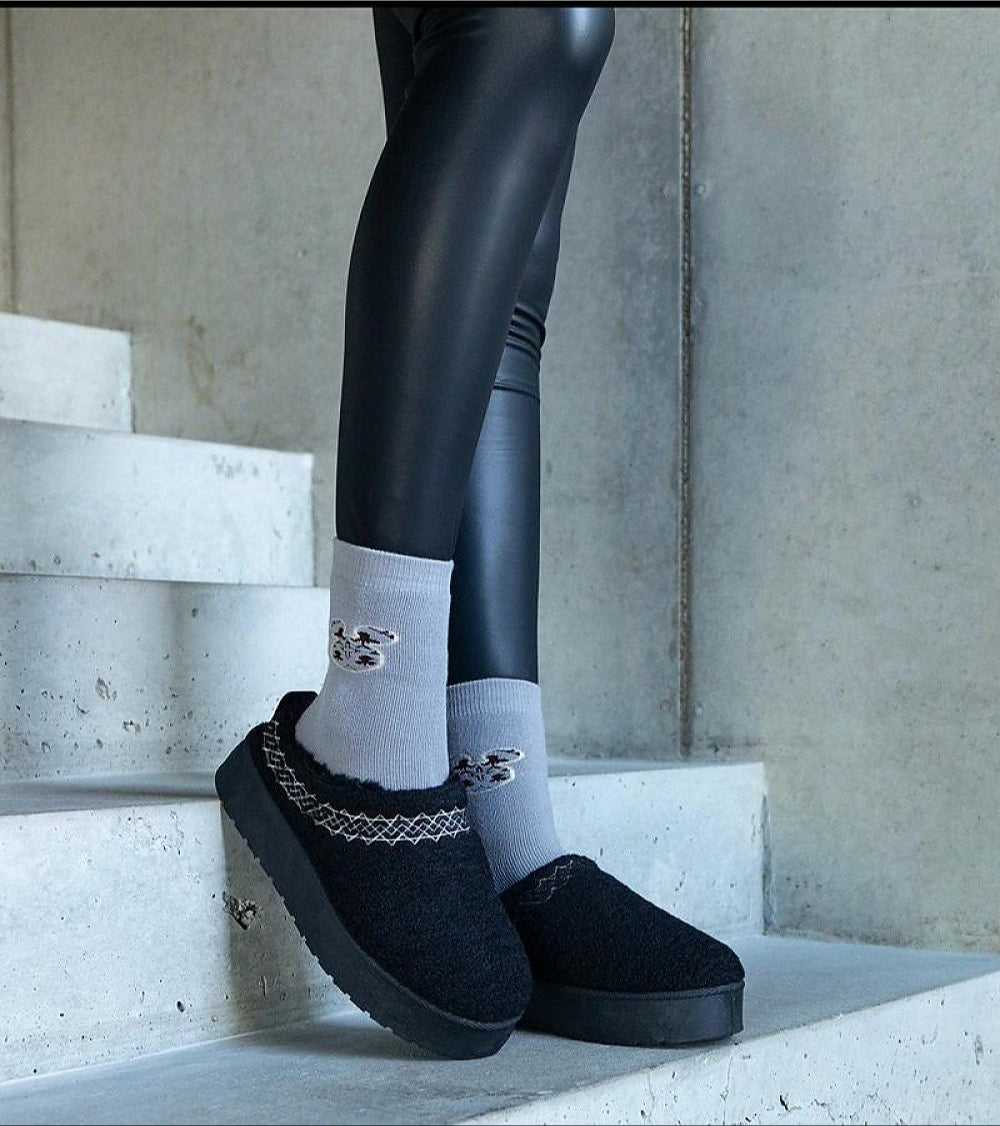 Person wearing Tavelya Embroidered Winter Snow Boots with grey socks, standing on concrete steps in stylish winter footwear.