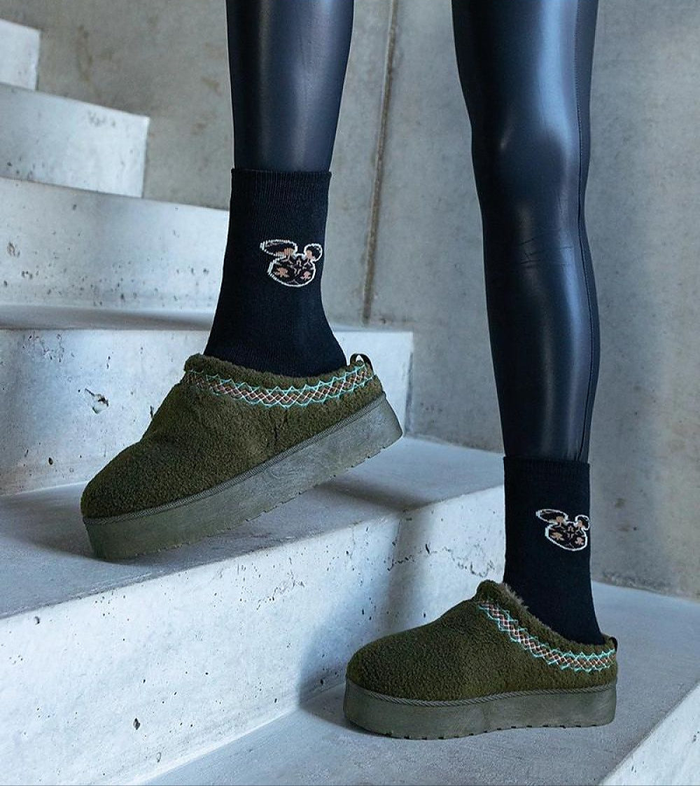 Model wearing Tavelya Embroidered Winter Snow Boots with black socks, showcasing comfort and style on concrete stairs.