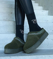 Person wearing Tavelya Embroidered Winter Snow Boots on stairs, featuring embroidered detailing and rubber soles for traction.