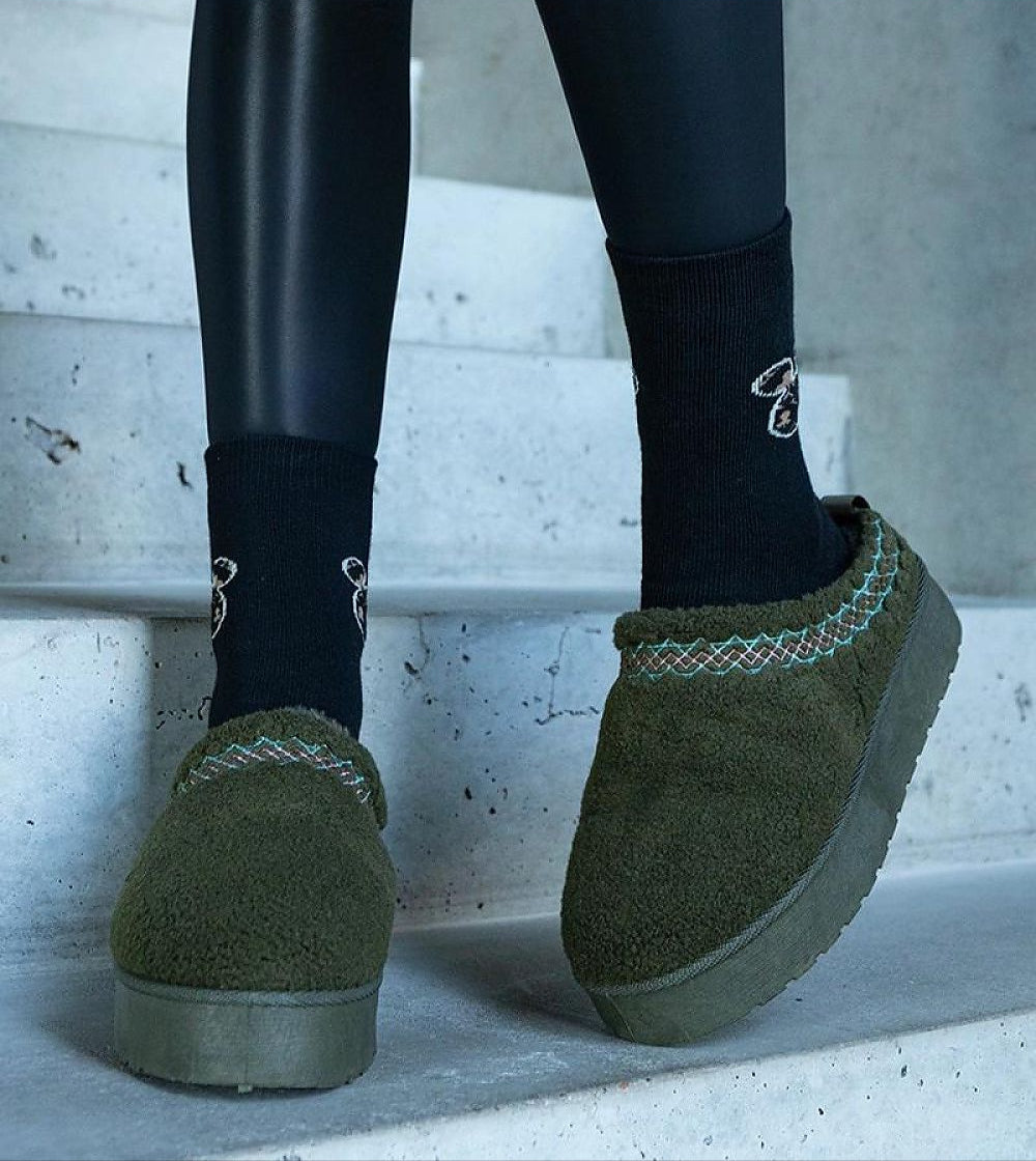 Green embroidered snow boots with black socks